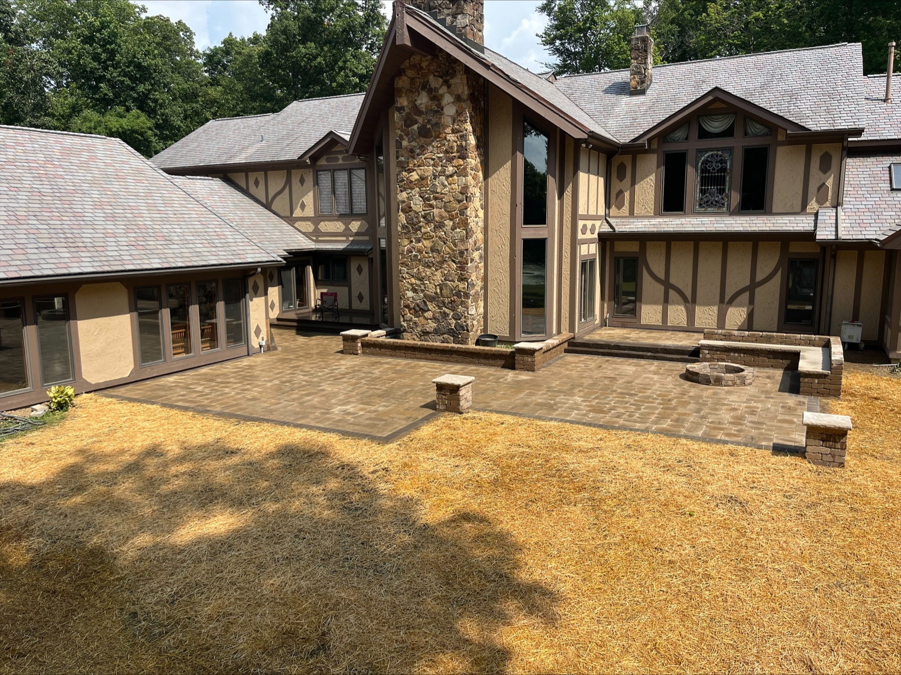 Large completed paver patio with seat walls and fire pit