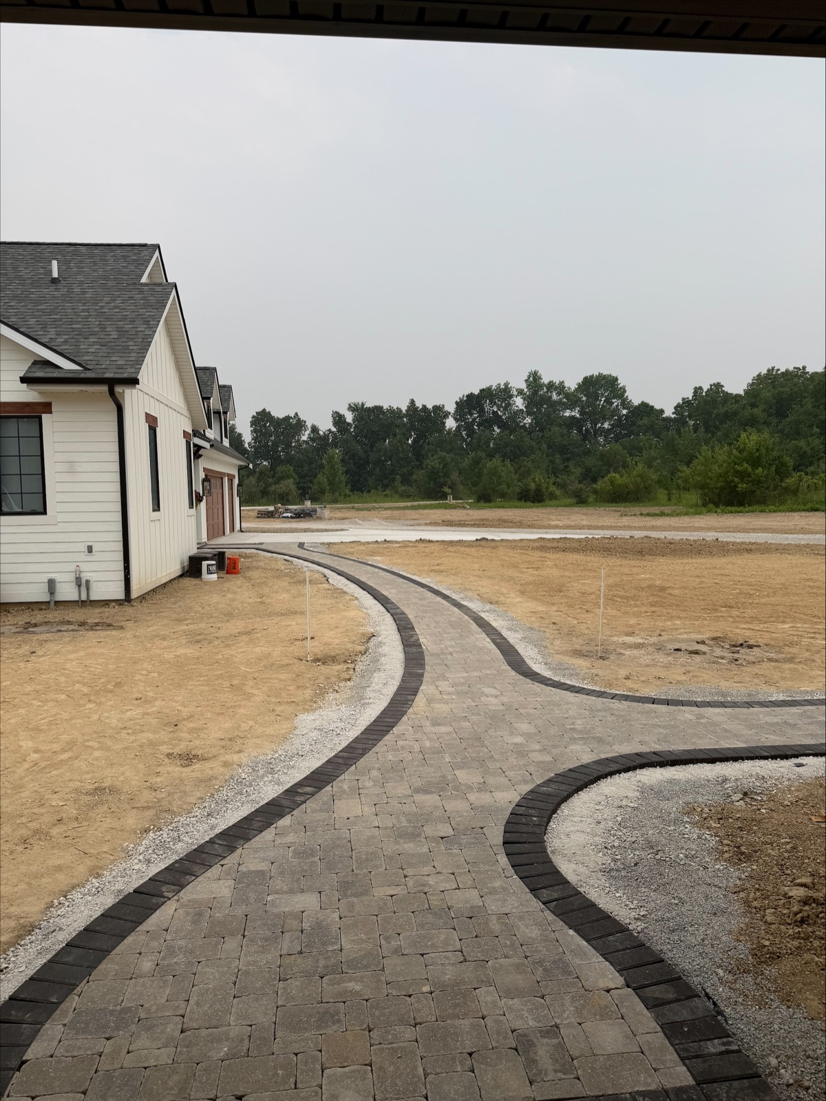 Curving paver walkway during landscape installation